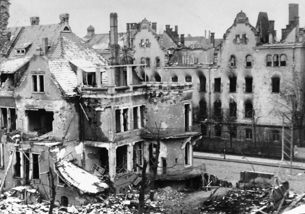 Das Haus der Demokratie wurde 1944 zerstört. Das Bild zeigt die ausgebrannten Fenster, das zerstörte Dach. Das Haus davor ist ebenfalls schwer beschädigt und teilweise eingestürzt.